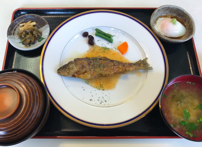 A set meal plate of fish, miso soup, onsen egg, rice, and pickles.