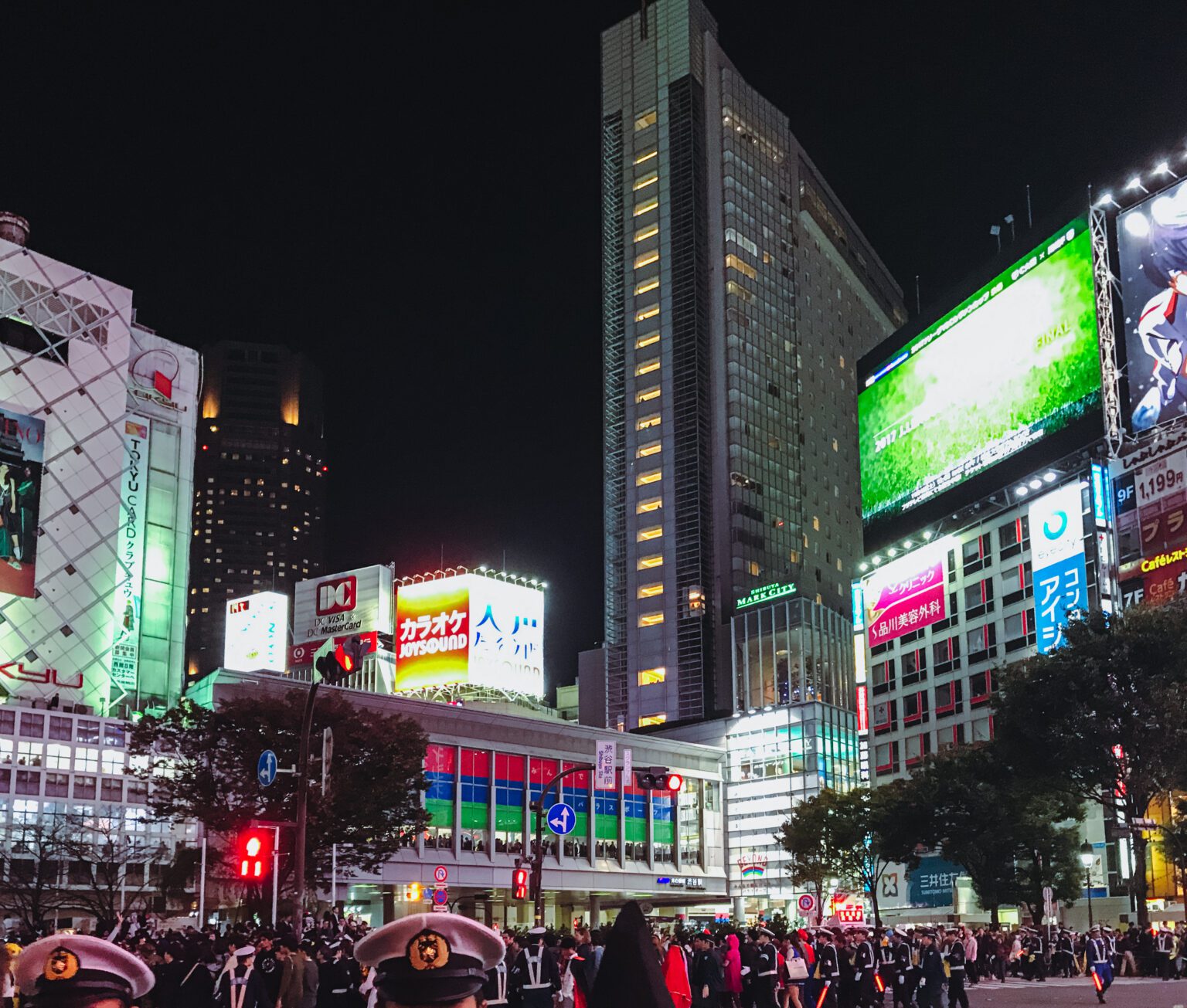 Shibuya crossing on Halloween. The station and buildings light up the street of people below