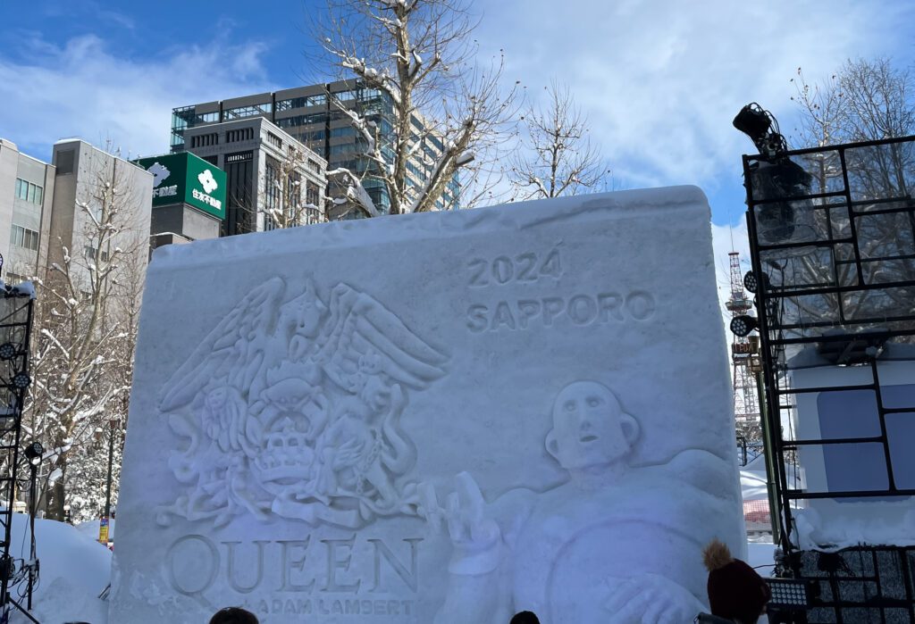 snow sculpture of the queen band logo