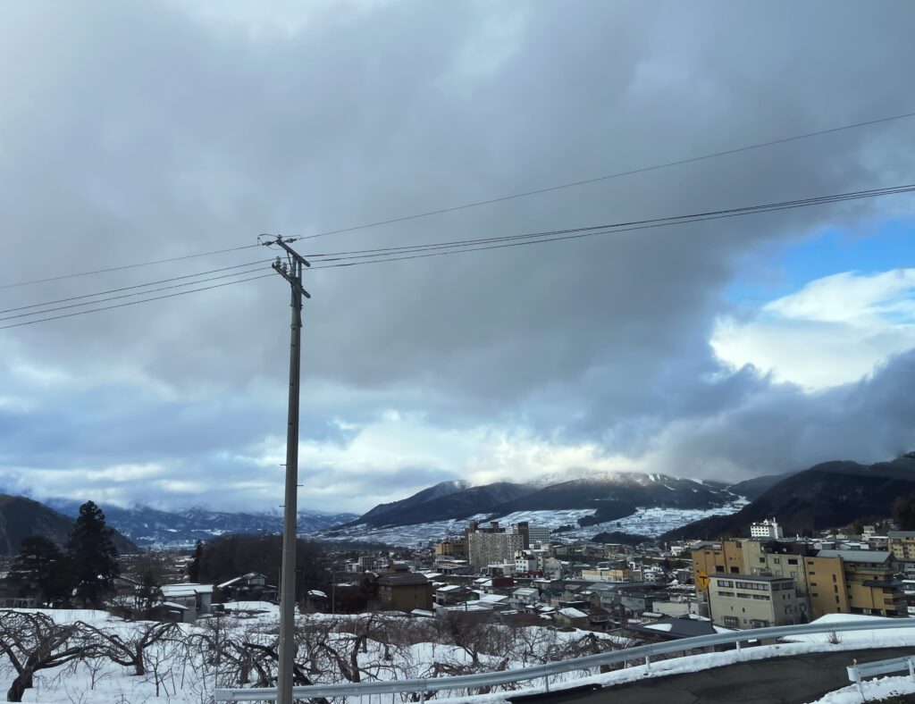 photo of nagano's town and cloudy sky, taken from the road